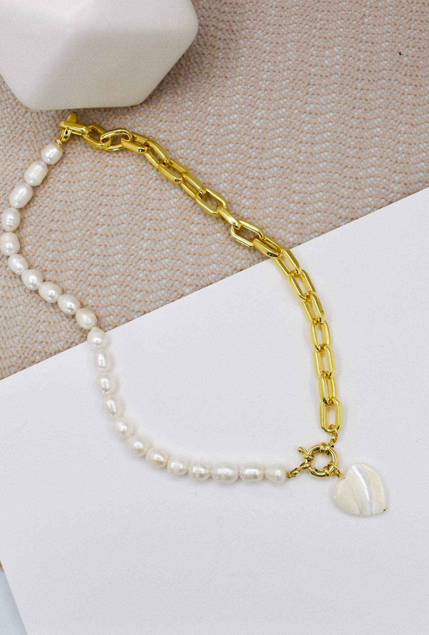full photo of a pearl and chain heart necklace on a white background