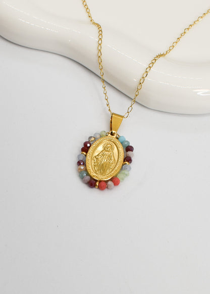 Gold necklace with a religious pendant on a white background