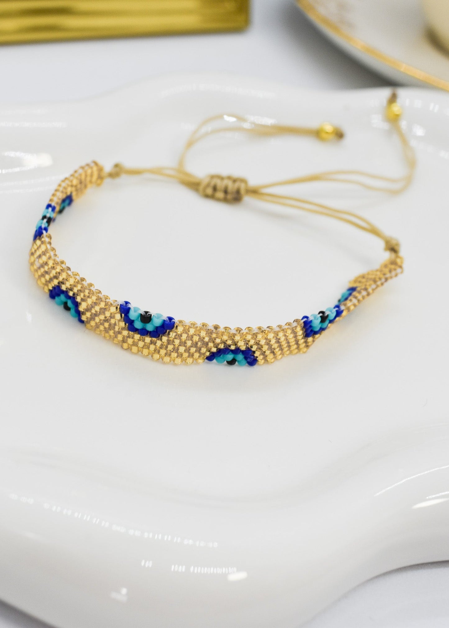 evil eye bar bracelet golden bar on a white tray