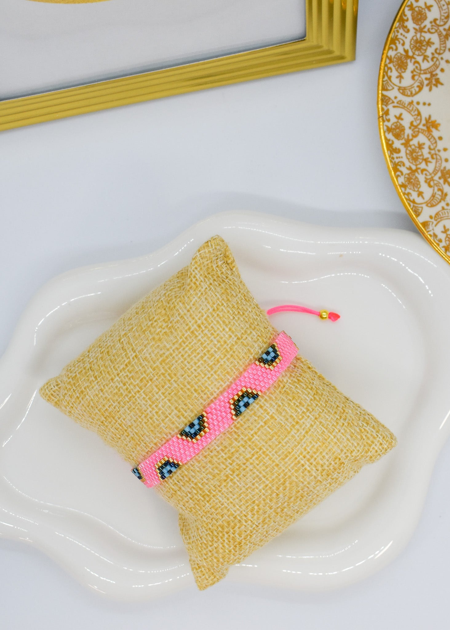 evil eye bar bracelet pink bar on a pillow display