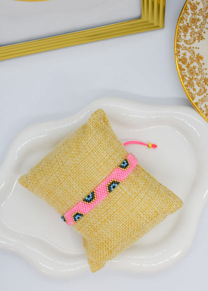 evil eye bar bracelet pink bar on a pillow display