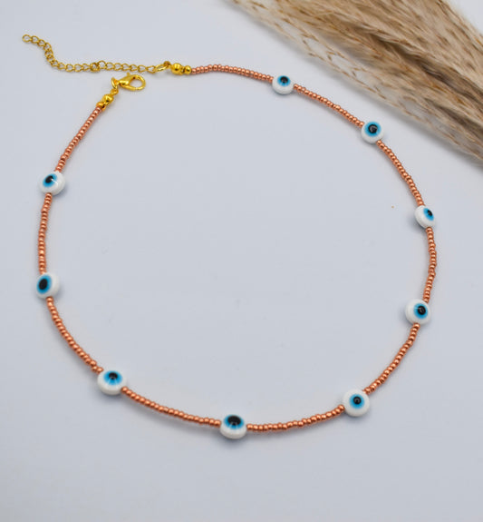 evil eye golden necklace on a white surface