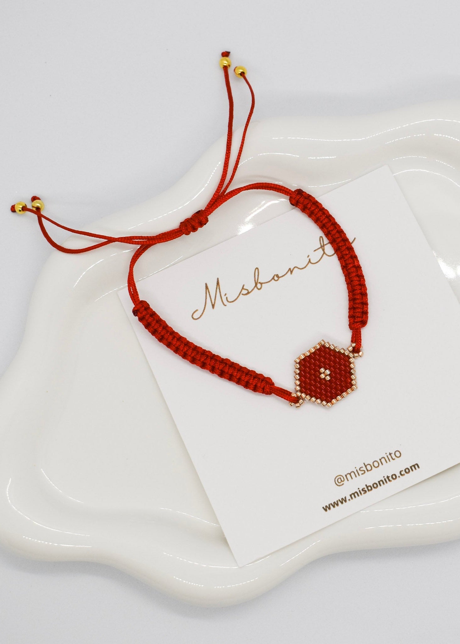 Brown bracelet with hexagonal bead on a white card with 'Misbonito' branding.
