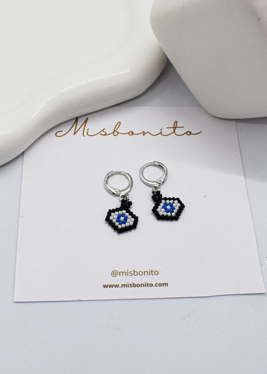 evil eye earrings with a decorative design on a 'Misbonito' branded card.