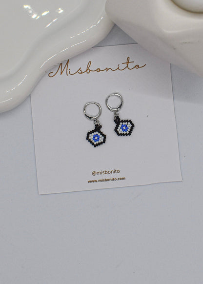 Pair of evileye beaded earrings on a 'Misbonito' branded card against a white background