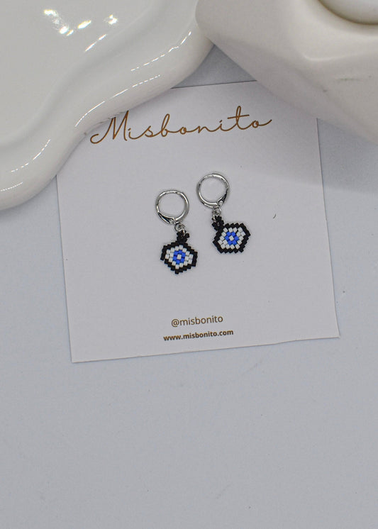 Pair of evileye beaded earrings on a 'Misbonito' branded card against a white background
