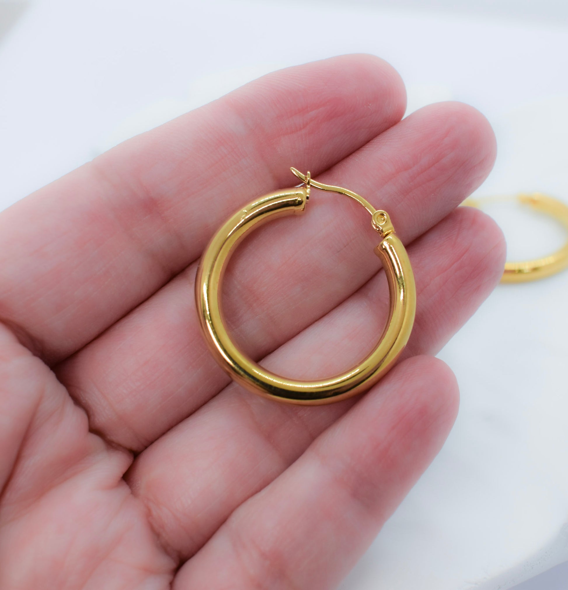 a hand holding golden hoops