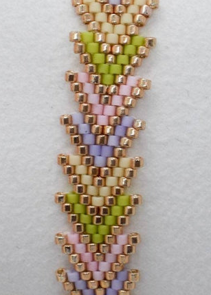 Beaded bracelet with a chevron pattern on a white cushion