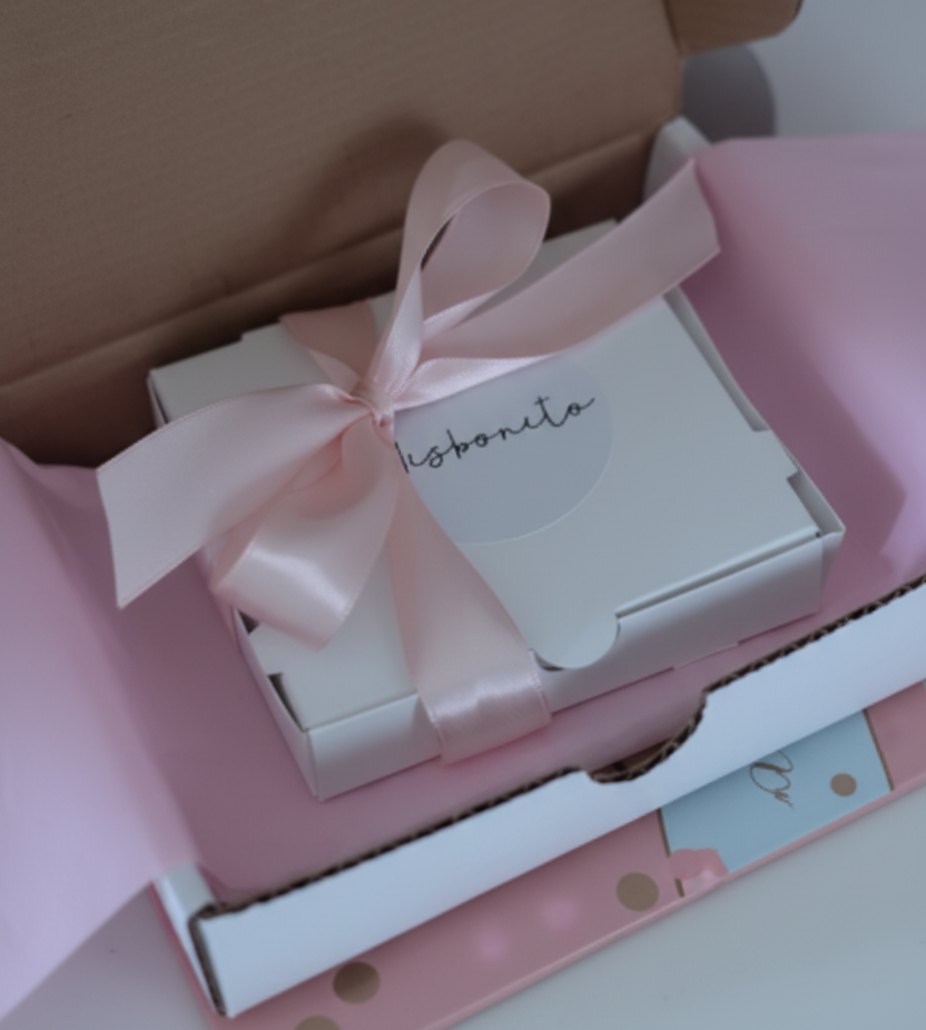 Gift box with a pink ribbon and 'Thank you' card on a polka dot surface
