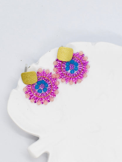 pink beaded round earrings on a white tray