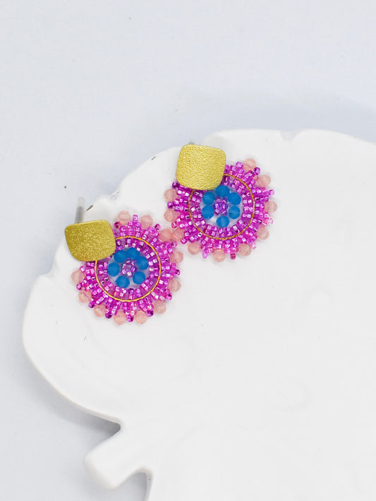 pink beaded round earrings on a white tray