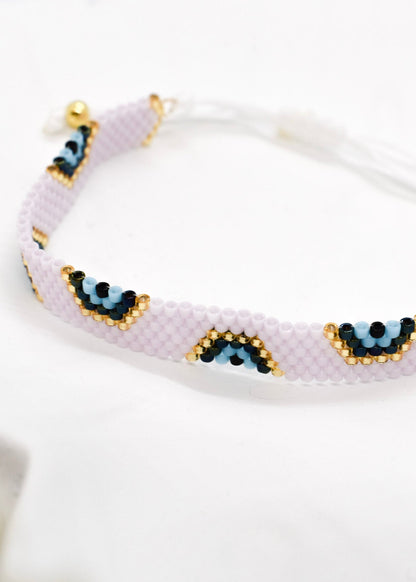 Beaded bracelet with eye designs on a white background