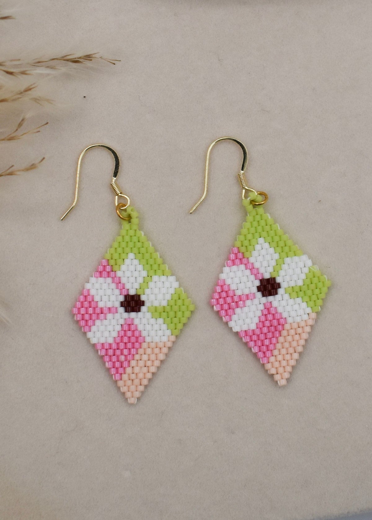 pink beaded earrings on beige background