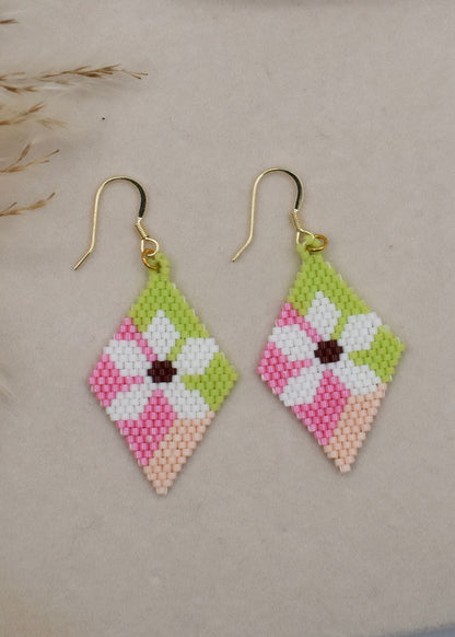 pink beaded earrings on beige background