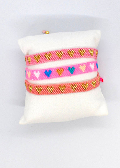 Set of colorful bracelets on a white cushion with a light gray background