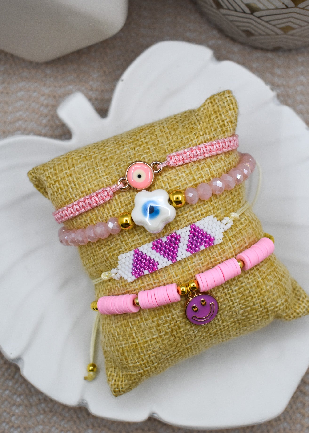 Set of colorful bracelets on a small pillow-like object on a textured surface