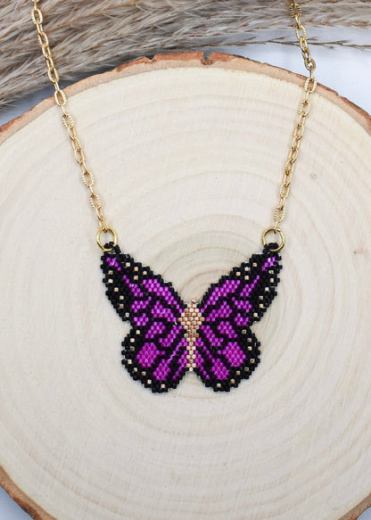 purple butterfly necklace on a wood background
