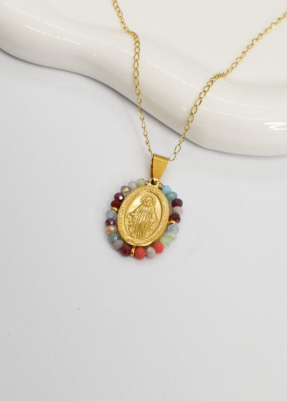 Gold necklace with a religious pendant on a white background