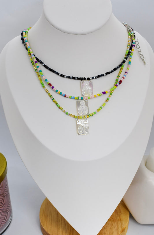 scapular white shell necklaces on a bust display