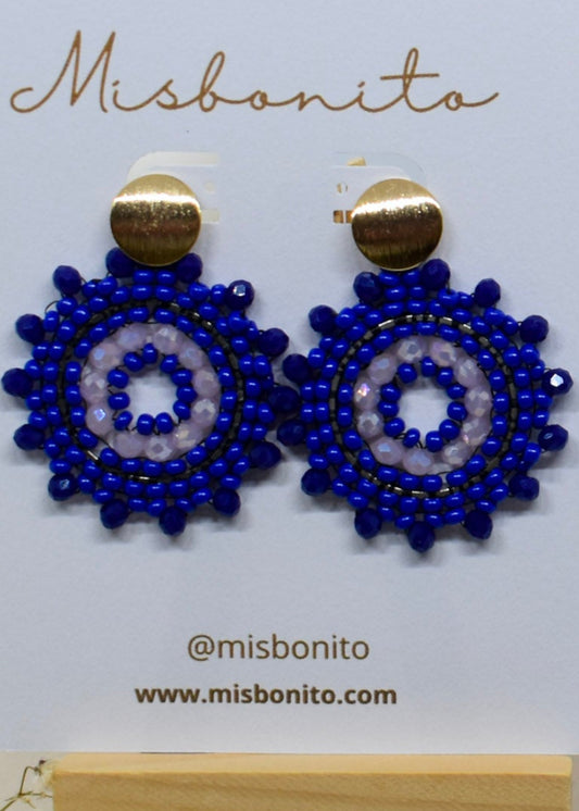 Blue beaded earrings on a Misbonito branded card with flowers in the background