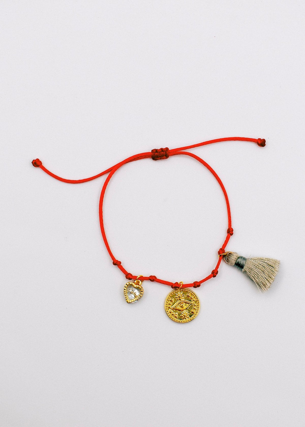 tassel and charms bracelet on a white surface