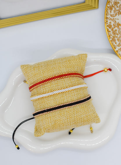 thin bracelets red white and black on a pillow
