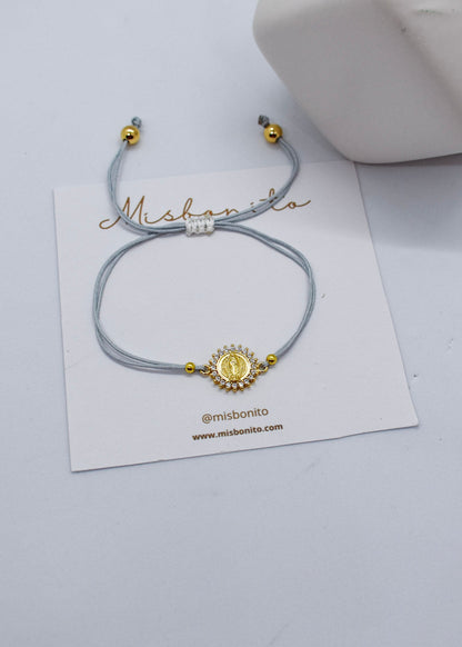 Bracelet with gold accents on a white card with 'Mishonito' branding, on a light gray background.