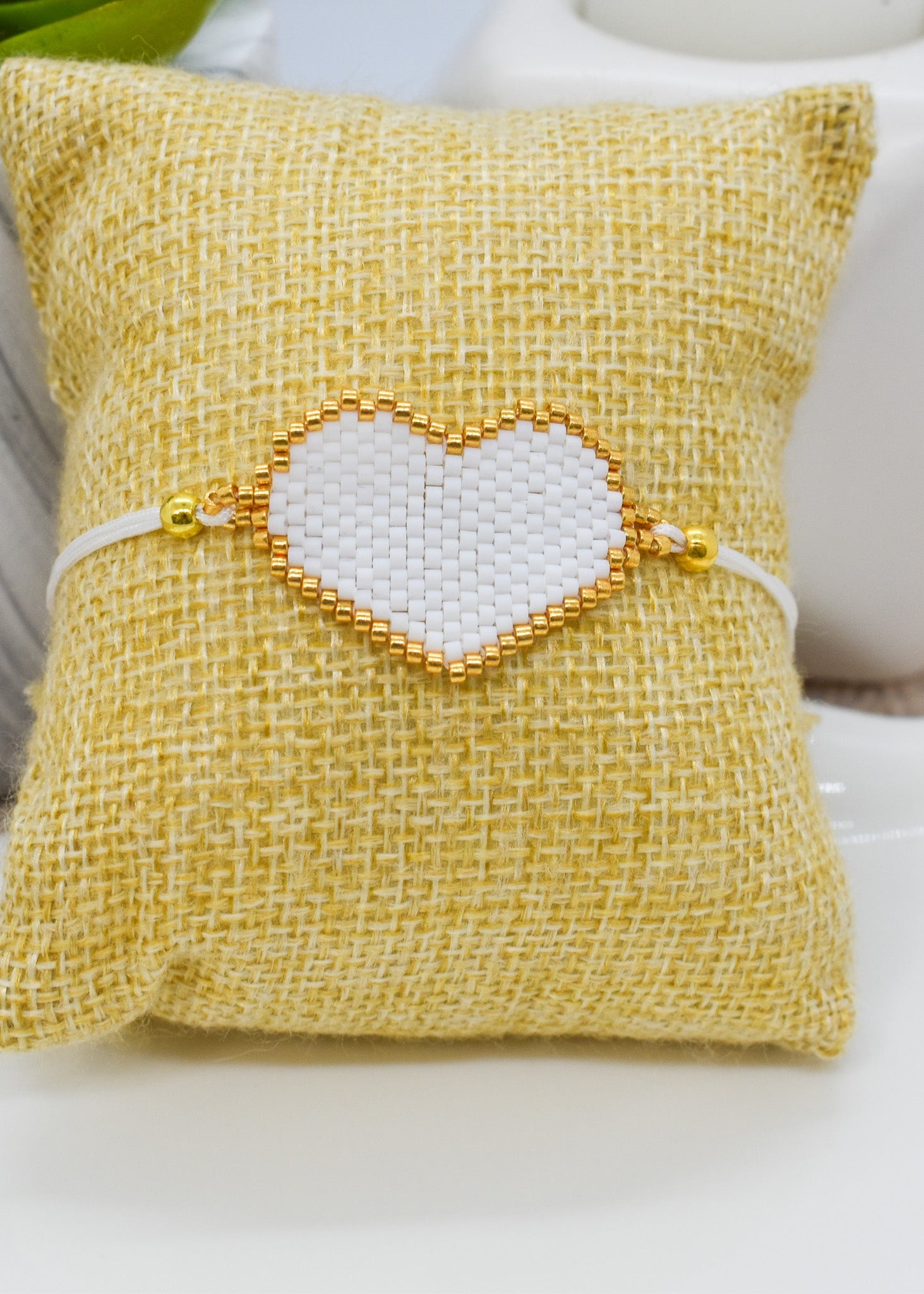 white heart bracelet on a pillow 