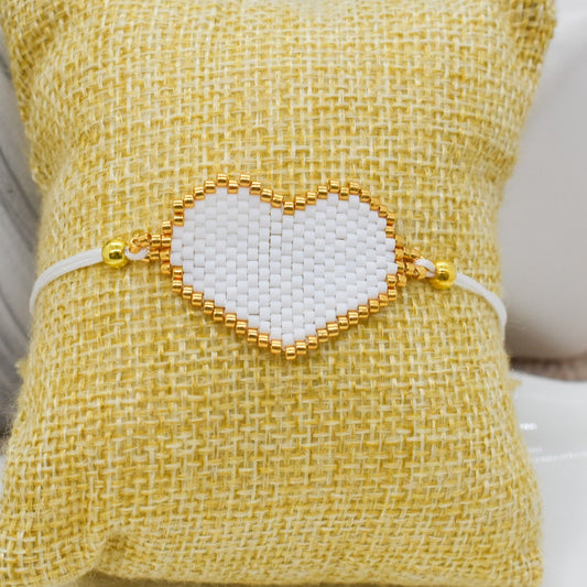 white heart bracelet on a pillow 