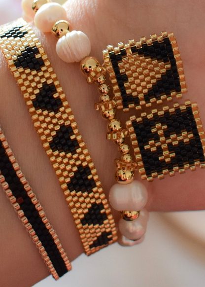 Beaded bracelet and earrings with geometric pattern on a neutral background
